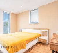 NA PREDAJ NADŠTANDARDNÁ 4-IZB. NOVOSTAVBA, DUN. KLÁTOV - Svetlá spálňa s drevenou podlahou a žltou prikrývkou v rodinnom dome.