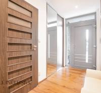 NA PREDAJ NADŠTANDARDNÁ 4-IZB. NOVOSTAVBA, DUN. KLÁTOV - Chodba v rodinnom dome s drevenou podlahou, zrkadlom a dverami s geometrickými prvkami.