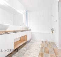 NA PREDAJ NADŠTANDARDNÁ 4-IZB. NOVOSTAVBA, DUN. KLÁTOV - Kúpeľňa v rodinnom dome s umývadlami, bielymi stenami a drevenou podlahou.