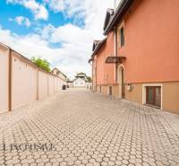 NA PREDAJ PENZIÓN VO VEĽKOM MEDERI – SUNGARDEN - Plochá cesta lemovaná oranžovou budovou v priestoroch hotelov a penziónov Veľkého Medera.