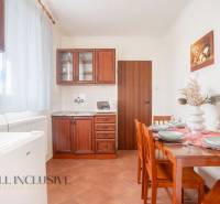 NA PREDAJ PENZIÓN VO VEĽKOM MEDERI – SUNGARDEN - Kuchynka v Hoteloch a penziónoch s drevenými skrinkami, stolom a dekoráciou na stole.