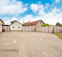 NA PREDAJ PENZIÓN VO VEĽKOM MEDERI – SUNGARDEN - Parkovisko v Hoteloch a penziónoch vo Veľkom Mederi s okolitými budovami a oblohou.