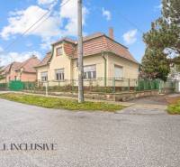 REZERVOVANÉ 4-IZBOVÝ RODINNÝ DOM, TOPOĽNÍKY - Rodinný dom v Topoľníkoch s červenou strechou a vysokým stromom pri ceste.