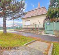 REZERVOVANÉ 4-IZBOVÝ RODINNÝ DOM, TOPOĽNÍKY - Rodinný dom v Topoľníkoch s veľkým stromom a kovovým plotom.