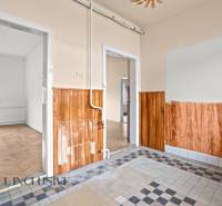 REZERVOVANÉ 4-IZBOVÝ RODINNÝ DOM, TOPOĽNÍKY - Interiér rodinného domu s mozaikovou dlažbou a stenami s dreveným obkladom.