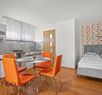 NA PREDAJ APARTMÁNOVÝ DOM VO VEĽKOM MEDERI - Pokoj v hoteloch a penziónoch s oranžovými stoličkami, kuchynským kútom a posteľou.