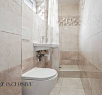 NA PREDAJ APARTMÁNOVÝ DOM VO VEĽKOM MEDERI - Kúpeľňa s toaletou, sprchou, umývadlom a obkladom v svetlých tónoch vhodná pre Hotely a penzióny.