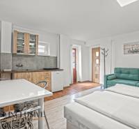 NA PREDAJ APARTMÁNOVÝ DOM VO VEĽKOM MEDERI - Kuchynský kút so sedačkou a dvojposteľou, podlaha s dreveným dekorom. Hotely a penzióny.