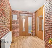 NA PREDAJ 6-IZBOVÝ POSCH. RODINNÝ DOM, HORNÉ SALIBY - Vstupná chodba s tehlovými stenami a podlahou s dreveným dekorom v rodinnom dome.