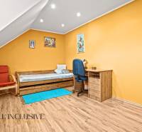 NA PREDAJ 6-IZBOVÝ POSCH. RODINNÝ DOM, HORNÉ SALIBY - Podkrovná izba s oranžovými stenami, nábytkom a podlahou s dreveným dekorom.