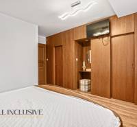 NA PREDAJ 6-IZBOVÝ POSCH. RODINNÝ DOM, HORNÉ SALIBY - Spálňa v rodinnom dome s posteľou a šatníkovou skriňou s dreveným dekorom.