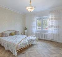 ZĽAVA - 3 IZBOVÝ RODINNÝ DOM, BLÍZKO CENTRA DUN.STREDY - Spálňa v rodinnom dome s postelí, květinovými tapetami a podlahou s dreveným dekorom.