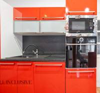 NA PREDAJ RODINNÉ DOMY S GARÁŽOU, DUNAJSKÁ STREDA - Červená kuchyňa v rodinnom dome s drezom a zabudovanou rúrou.