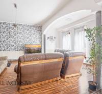 NA PREDAJ RODINNÉ DOMY S GARÁŽOU, DUNAJSKÁ STREDA - Obývačka rodinného domu s koženými pohovkami, tapetou a veľkými oknami.