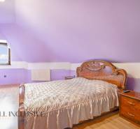 NA PREDAJ RODINNÉ DOMY S GARÁŽOU, DUNAJSKÁ STREDA - Fialová spálňa v rodinnom dome s drevenou posteľou a nočnými stolíkmi.
