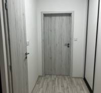 NOVÝ ZARIADENÝ KRÁSNY BYT S TERASOU - Úzka chodba so svetlými dverami a podlahou, ideálna pre 1-izbový byt na ulici Muškátová.