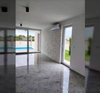 VRSI - dvojdom s bazénom a záhradou - Interiér rodinného domu s klimatizáciou, veľkými oknami a výhľadom na bazén.