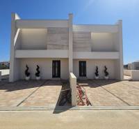 VRSI - dvojdom s bazénom a záhradou - Rodinný dom na ulici Mulo vo Vrsi s dlaždeným chodníkom a dekoratívnymi rastlinami.