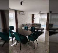 VRSI - dvojdom s bazénom a záhradou - Jedáleň v rodinnom dome s mramorovou podlahou, jedálenským stolom a sivou sedačkou.