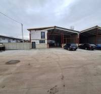 Na predaj sklad - hala, ul. Strojnícka, Prešov - Priemyselná budova na Strojníckej ulici v Prešove s parkovacími miestami a autami.