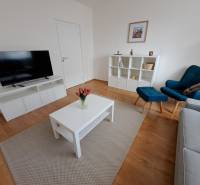 REZERVOVANÉ! Prenajmeme 3-izb. byt, 78 m2, Vráble, okr. Nitra - Obývacia izba v 3-izbovom byte s podlahou s dreveným dekorom a jednoduchým nábytkom.