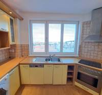 Prenájom pekného a priestranného 4-izbového bytu vo Svite - Kuchyňa v 4-izbovom byte s podlahou s dreveným dekorom a výhľadom na mesto.