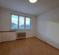 Prenájom pekného a priestranného 4-izbového bytu vo Svite - Miestnosť v 4-izbovom byte s podlahou s dreveným dekorom a veľkým oknom.