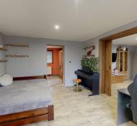 Rodinný dom Unín s pozemkom 941 m2 - Izba v rodinnom dome s pianom, posteľou a podlahou s dreveným dekorom.