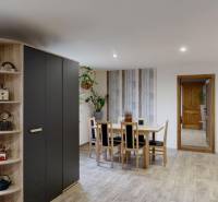 Rodinný dom Unín s pozemkom 941 m2 - Jedáleň v rodinnom dome s dreveným dekorom podlahy a priestrannými skrinkami.