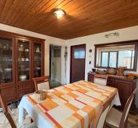 Exkluzívny PREDAJ 4 izbového rodinný domu s garážou, Zlatná na Ostrove - Jedáleň v rodinnom dome so stolom, stoličkami a skriňou, podlaha s dreveným dekorom.