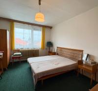 Exkluzívny PREDAJ 4 izbového rodinný domu s garážou, Zlatná na Ostrove - Spálňa s jednoduchým nábytkom v rodinnom dome, zelený koberec a žlté záclony.