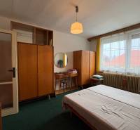 Exkluzívny PREDAJ 4 izbového rodinný domu s garážou, Zlatná na Ostrove - Spálňa rodinného domu s kobercovou podlahou, dreveným nábytkom a veľkým oknom.