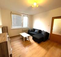 EXKLUZÍVNY PREDAJ - 1 izbový byt Revolučná Štvrť , Galanta - Obývacia izba v 1-izbovom byte so sedačkou a podlahou s dreveným dekorom.