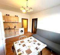 EXKLUZÍVNY PREDAJ - 1 izbový byt Revolučná Štvrť , Galanta - Kuchyňa so sedačkou v 1-izbovom byte, podlaha s dreveným dekorom, jedálenský stôl.