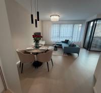 Exk. prenájom lux. 2 iz bytu Rezidencia Blumental - Interiér 2-izbového bytu s podlahou s dreveným dekorom, jedálenským stolom a balkónom.