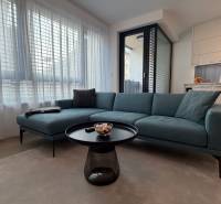 Exk. prenájom lux. 2 iz bytu Rezidencia Blumental - Obývačka s pohovkou, stolíkom a kuchynským kútom v 2-izbovom byte.