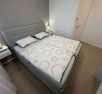 Exk. prenájom lux. 2 iz bytu Rezidencia Blumental - Spálňa s manželskou posteľou a podlahou s dreveným dekorom v 2-izbovom byte.