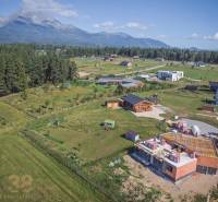 Jedinečný stavebný pozemok v krásnej lokalite Tatranské Smaragdy - Pozemky - bývanie v Mlynici s výhľadom na hory a rozostavanými domami v prírode.