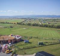 Jedinečný stavebný pozemok v krásnej lokalite Tatranské Smaragdy - Pozemky - bývanie v Mlynici s výhľadom na rozostavanú budovu a scenériu prírody.