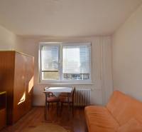 PRENÁJOM - Garsónka, Hlavná ulica Galanta - Garsónka s pohovkou, stolom a skriňou, podlaha s dreveným dekorom.