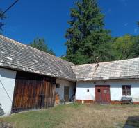 Hospodárska usadlosť s 3,6 hektárovým pozemkom na samote Nová Baňa - Tradičný rodinný dom so starou šindľovou strechou a drevenými dverami na dvore.