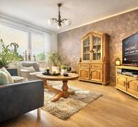 Prejaj nadčasového 4+1 bytu v skvelej lokalite Čadca- Žarec - Obývacia izba so sedačkou, dreveným nábytkom a podlahou s dreveným dekorom v 4-izbovom byte.