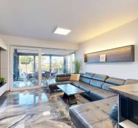 , predaj 4 izb. novostavby zariadeného RD, Jarná, Hviezdoslavov - Obývačka v rodinnom dome s koženou sedačkou a rozmernou presklenou stenou.