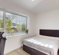 , predaj 4 izb. novostavby zariadeného RD, Jarná, Hviezdoslavov - Svetlá spálňa v rodinnom dome s posteľou, oknom a podlahou s dreveným dekorom.