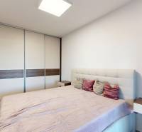 , predaj 4 izb. novostavby zariadeného RD, Jarná, Hviezdoslavov - Spálňa v rodinnom dome s veľkou skriňou a posteľou, podlaha s dreveným dekorom.