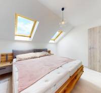 Krásny moderný 2 izbový byt v centre Bratislavy, nám. SNP - Spálňa v 2-izbovom byte s dvoma strešnými oknami, posteľou a drevenými prvkami.