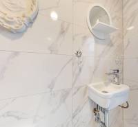 Krásny moderný 2 izbový byt v centre Bratislavy, nám. SNP - Umývadlo v kúpeľni s mramorovým obkladom a okrúhlym zrkadlom, 2-izbový byt.