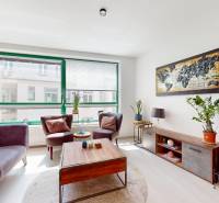 Krásny moderný 2 izbový byt v centre Bratislavy, nám. SNP - Obývacia izba v 2-izbovom byte s veľkým oknom, pohovkou a dekoráciami.