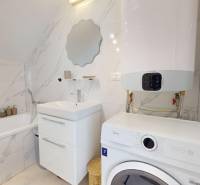 Krásny moderný 2 izbový byt v centre Bratislavy, nám. SNP - Kúpeľňa v 2-izbovom byte s práčkou, vaňou a zrkadlom na stene.