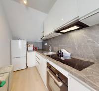 Krásny moderný 2 izbový byt v centre Bratislavy, nám. SNP - Kuchyňa v 2-izbovom byte s bielymi skrinkami a vstavanými spotrebičmi.